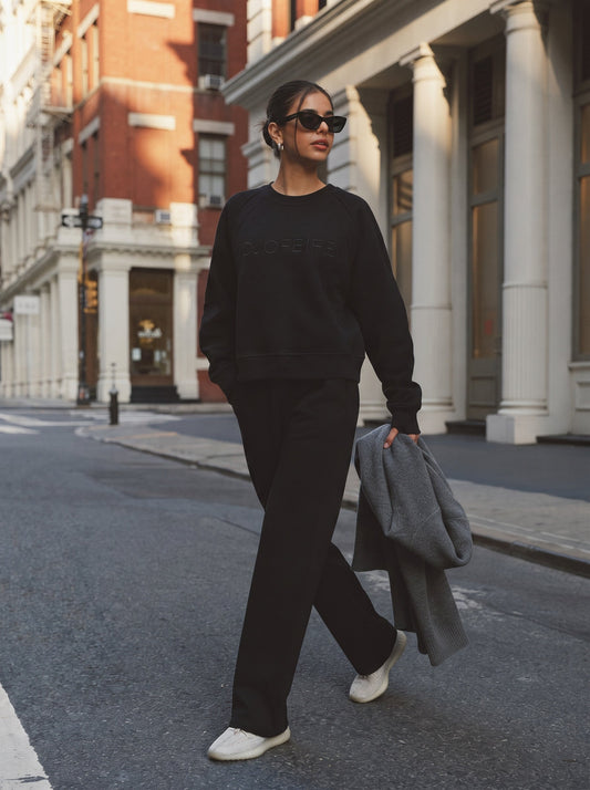 Woman wearing a black oversized crewneck sweatshirt